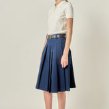 Side profile view of a navy low-waist pleated midi skirt displaying the clean side invisible zipper seam and flared silhouette.