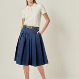 Face-forward posed view of a navy low-waist pleated midi skirt showcasing the tailored fit and A-line drape.