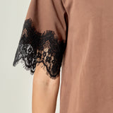 Ultra close-up detail view of brown cotton fabric paired with intricate black eyelash lace edging.