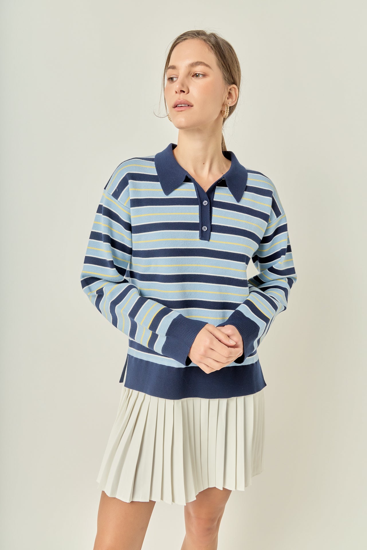 Face-forward posed view of a navy multi striped polo knit mini dress showcasing the sporty mixed-media silhouette.