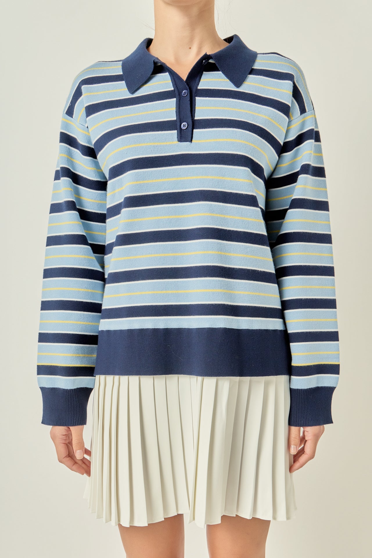 Upper body close-up view of a navy multi striped polo knit dress highlighting the dark blue collar and front button placket.