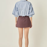 Full-length rear view of a dusty blue striped shirt displaying the back yoke detail and dramatic gathered balloon sleeves.