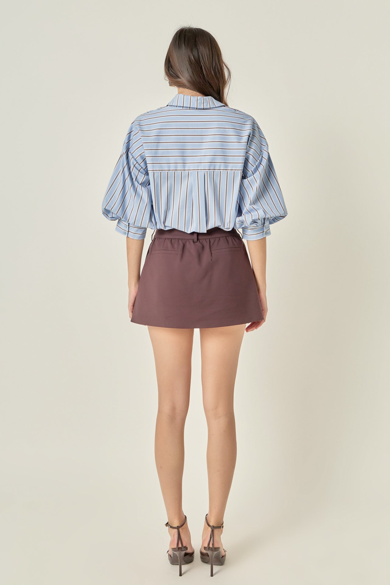 Full-length rear view of a dusty blue striped shirt displaying the back yoke detail and dramatic gathered balloon sleeves.